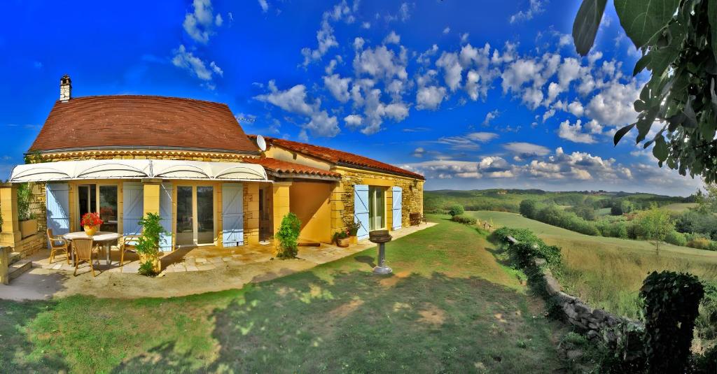 a small yellow house with a roof at Gite Four De Mon Père in Salignac Eyvigues