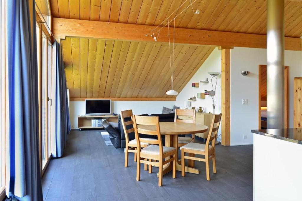 Un comedor y una cocina con mesa y sillas. en Chesa Filomela, en Bever