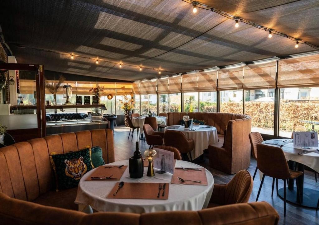 Un restaurante con mesas y sillas en una sala. en 't Haasnestje, en Harderwijk