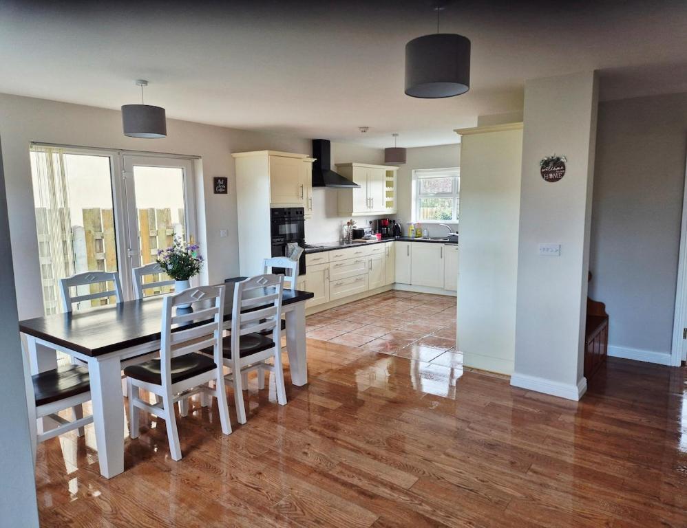 a kitchen and dining room with a table and chairs at Beautiful Spacious 4-Bedroom House in Louisburgh in Louisburgh