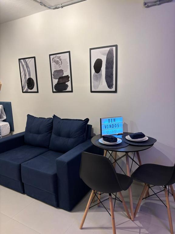 un soggiorno con un divano blu e un tavolo di Mirante Experience SP - Banheira com Hidro e TV 70 - Luxo, Conforto e Vista Incrível no Centro De São Paulo a San Paolo