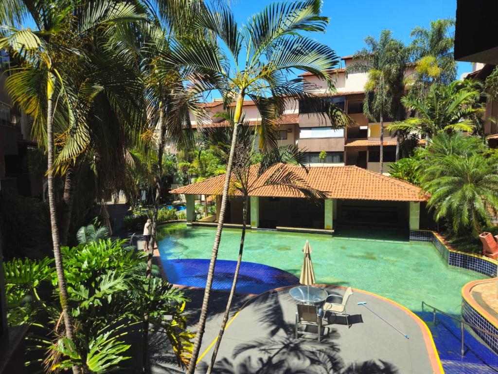 einen Luftblick auf einen Pool mit Palmen des Resorts in der Unterkunft Apto Residencial Aconchego2 em Rio Quente Go - Hot Park in Rio Quente