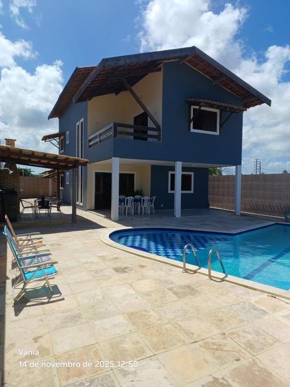 eine Villa mit Swimmingpool und ein Haus in der Unterkunft Casa de Praia Lucena in Lucena