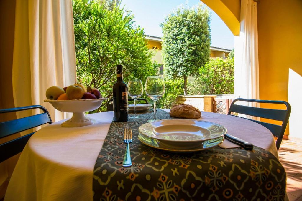 - une table avec une assiette de fruits et une bouteille de vin dans l'établissement Trilocale Cielo, à Alberese