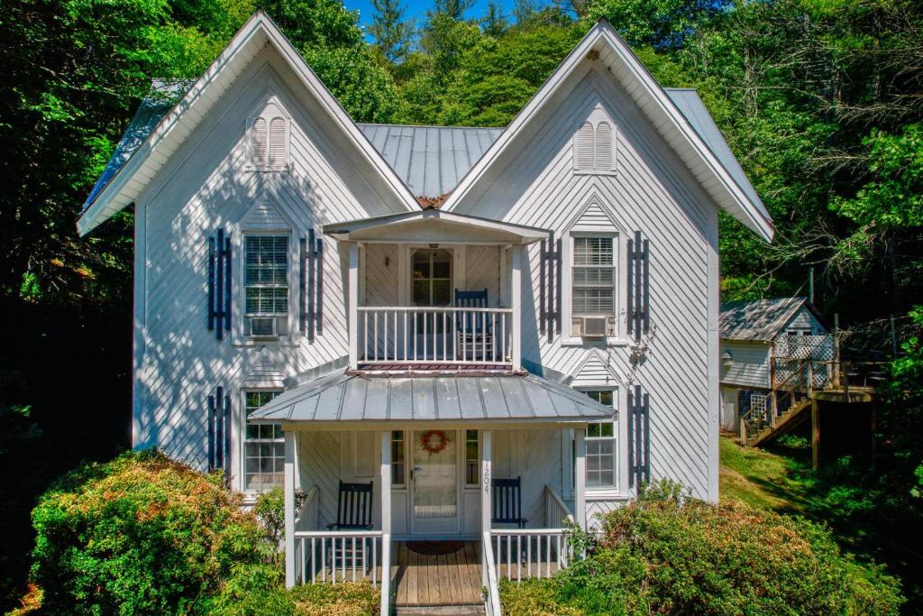 a white house with a porch and a balcony at Historic McGuire House in Todd
