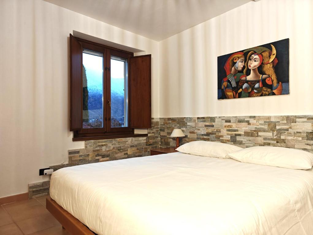 a bedroom with a bed and a painting on the wall at Lakefront with garden in Oria