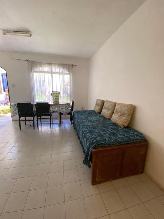 une chambre avec un lit, une table et des chaises dans l'établissement Apartamento El Gauchito en Cosquin, à Cosquín