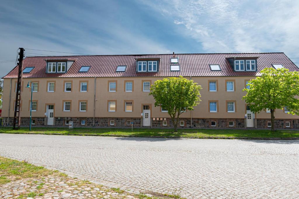ein großes Gebäude mit zwei Bäumen davor in der Unterkunft VIP Apartment 4A 2 Zi 40qm Küche Bad in Vierraden