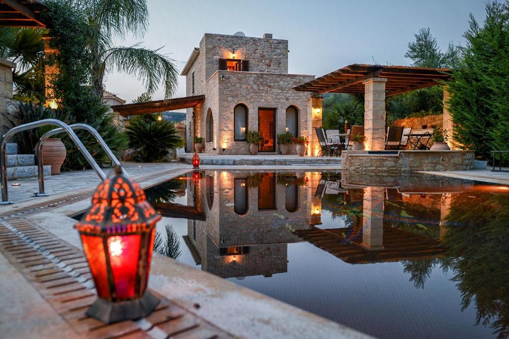 una casa con piscina frente a una casa en Olympia Villas, en Stoupa