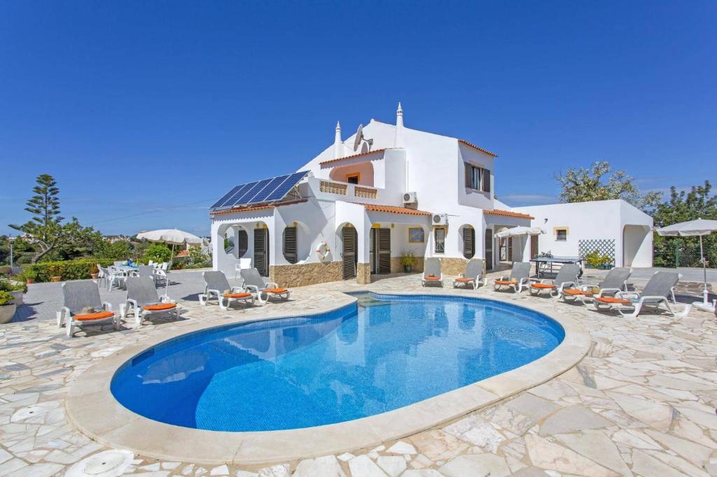 une villa avec piscine devant une maison dans l'établissement Villa Eira by Villa Plus, à Praia do Carvoeiro