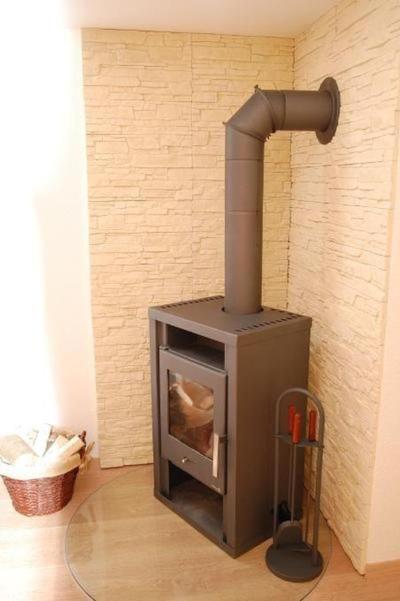 estufa en una habitación con pared de ladrillo en Waldstübchen, en Brotterode