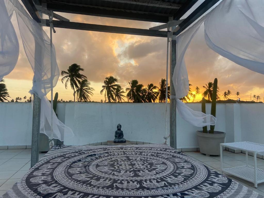 a room with a large mandala rug on a patio at Casa Paraiso Beira-Mar in Maracajaú