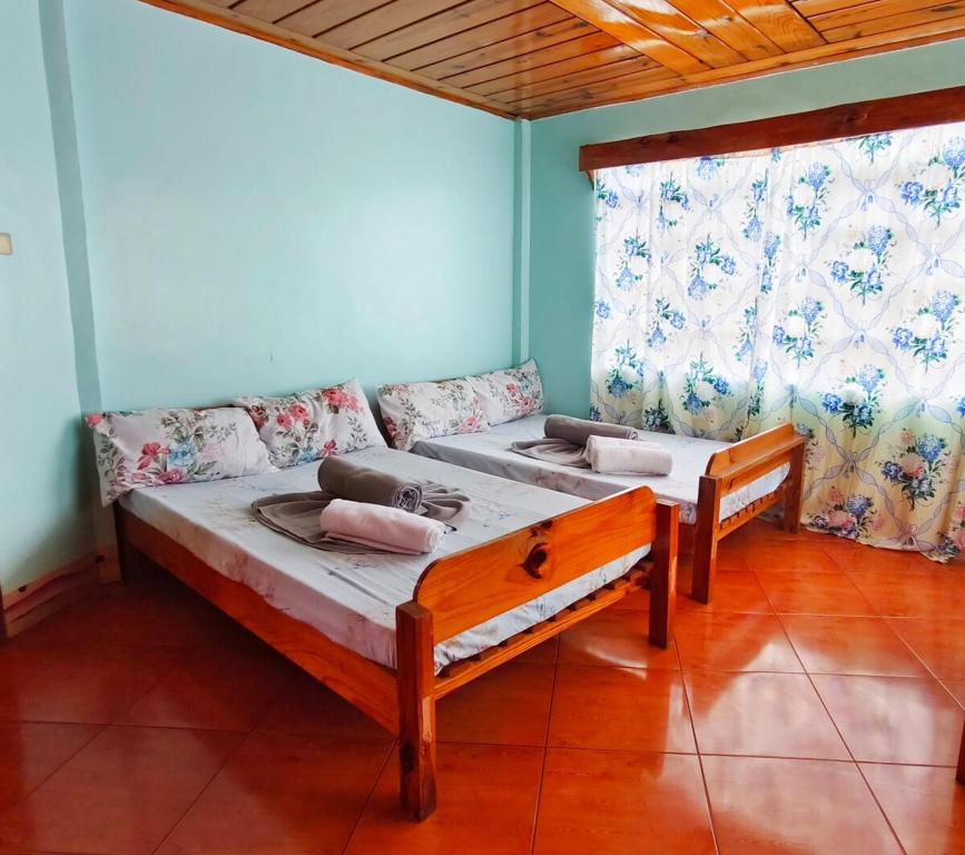 萨加达Bungalow Staycation with Terrace and Parking的一张沙发和一个窗户的客房内的两张床