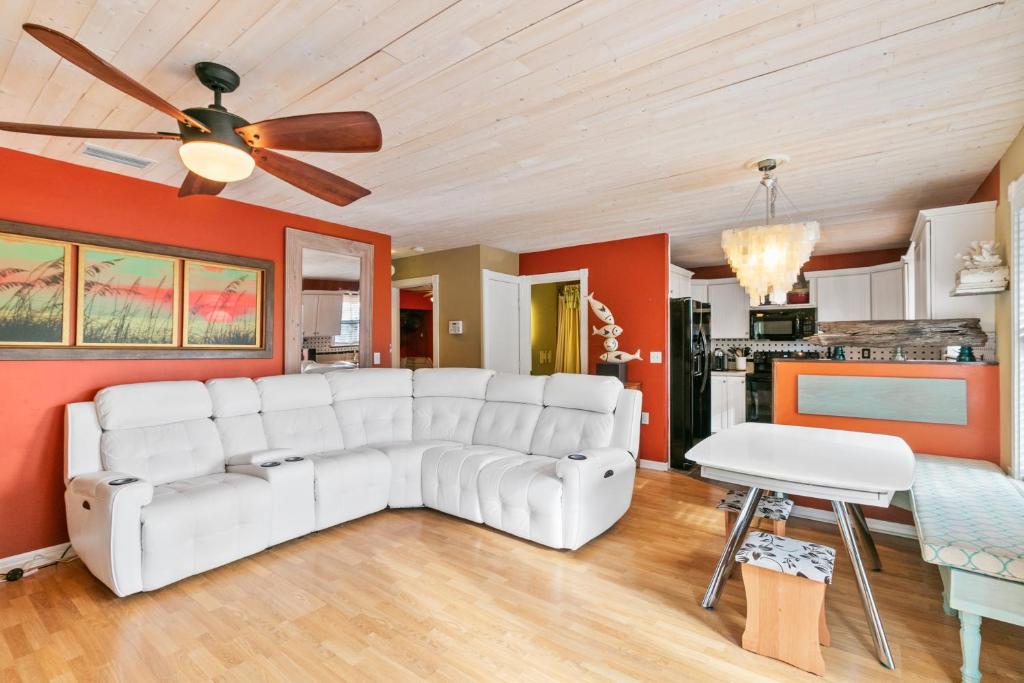 a living room with a white couch and a ceiling fan at Beach Breeze East in Bradenton Beach