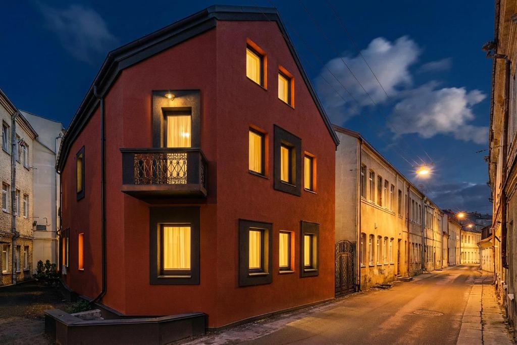 un edificio rosso con finestre illuminate su una strada di Chamber House a Kaunas