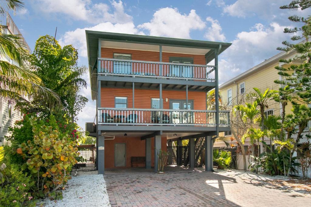 an apartment building with a balcony and a patio at Beach Breeze West in Bradenton Beach
