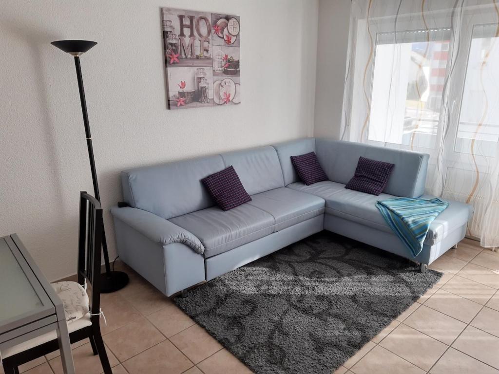 a blue couch in a living room with a rug at Chic 2-room apartment very central and quiet in Eislingen
