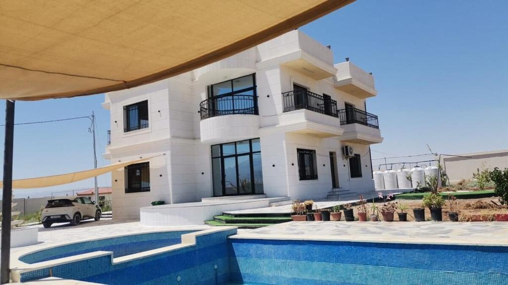 ein weißes Haus mit einem Swimmingpool davor in der Unterkunft Rest Sea Chaliet & Farm 