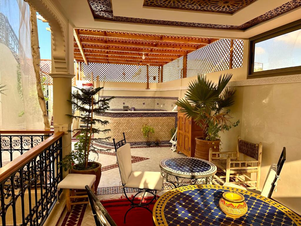 a balcony with a table and chairs on a balcony at Riad Rose Mati in Marrakech
