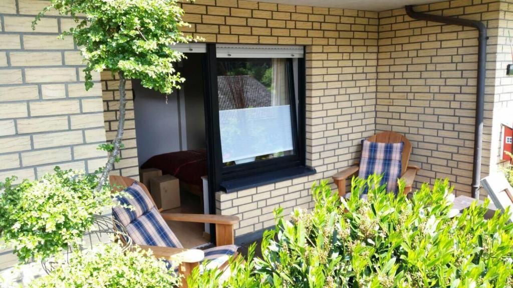 eine Veranda mit zwei Stühlen und eine Tür mit einem Fenster in der Unterkunft Ferienwohnung Himmelreich in Antfeld
