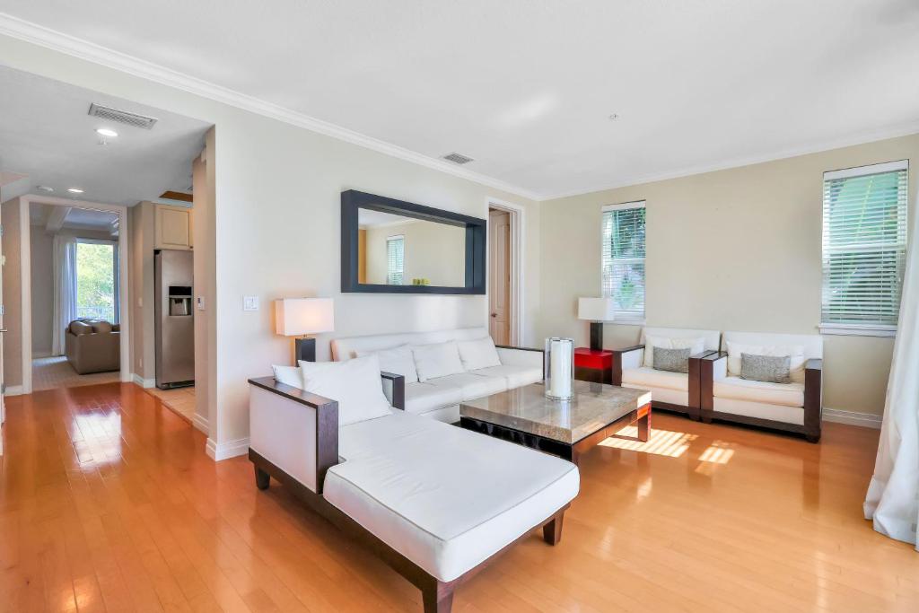 een woonkamer met een witte bank en een tafel bij Aqua Bay in Longbeach