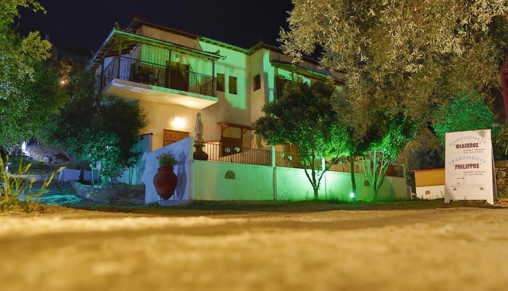 dom z zielonymi światłami na boku w obiekcie Philippos Apartments w mieście Afissos