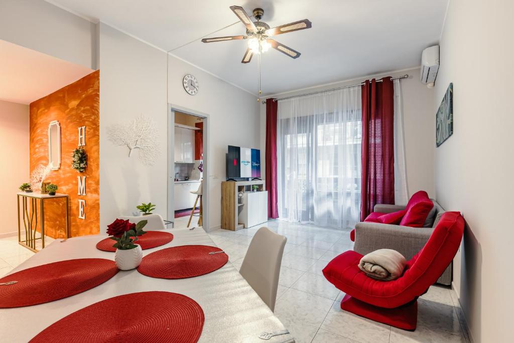 uma sala de estar com uma mesa e uma cadeira vermelha em Raf Rhome Seaside - Center 200m to the Sea em Lido di Ostia