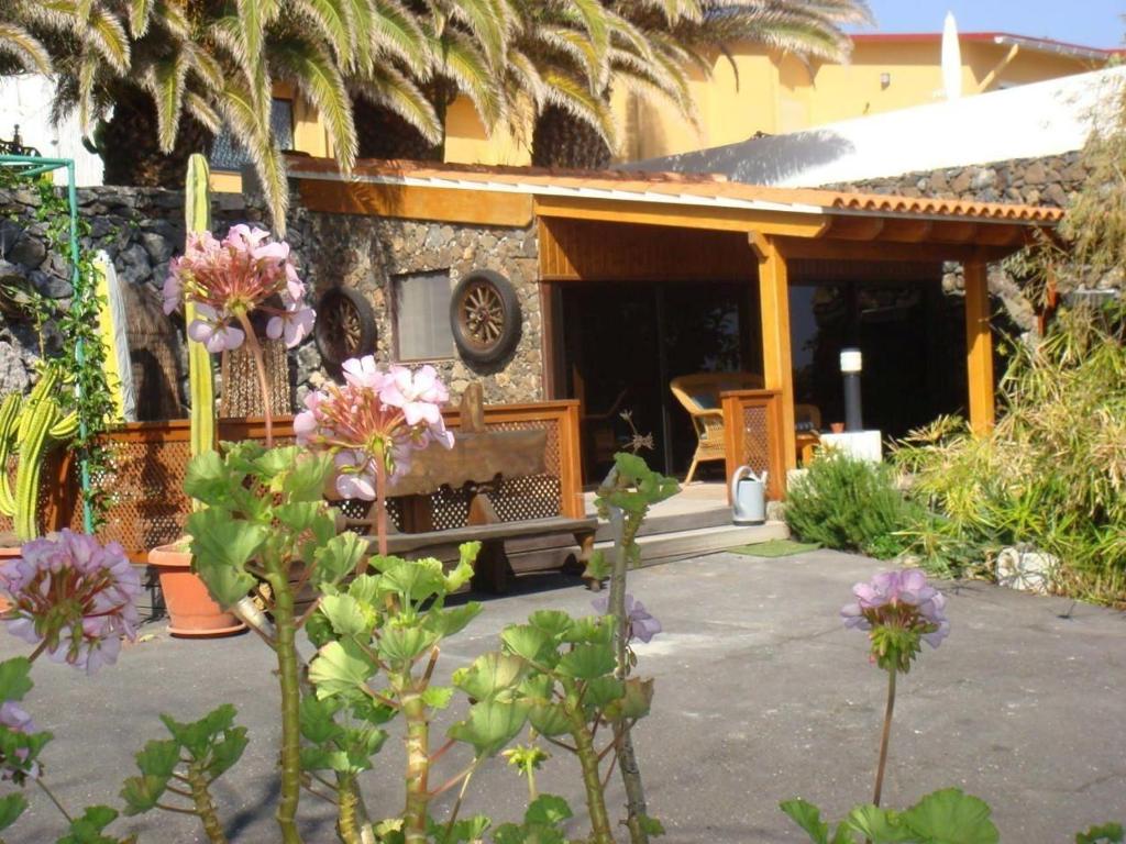 ein Haus mit einer Veranda mit Blumen davor in der Unterkunft Kleines Ferienhaus mit eigener, teils überdachter Terrasse in Alcalá