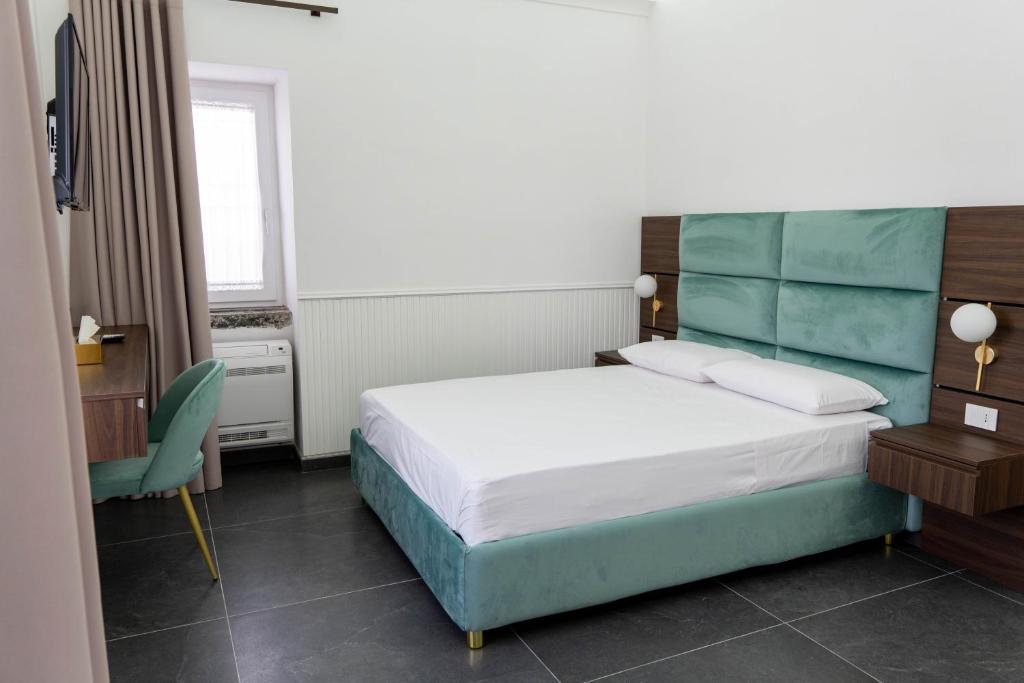 a hotel room with a bed and a chair at Carotenuto Palace in Boscotrecase