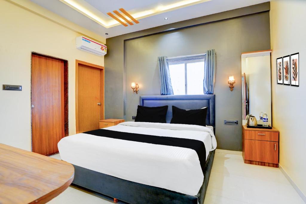 a bedroom with a large white bed and a window at Hotel O Fortune Palace in Hinjewadi