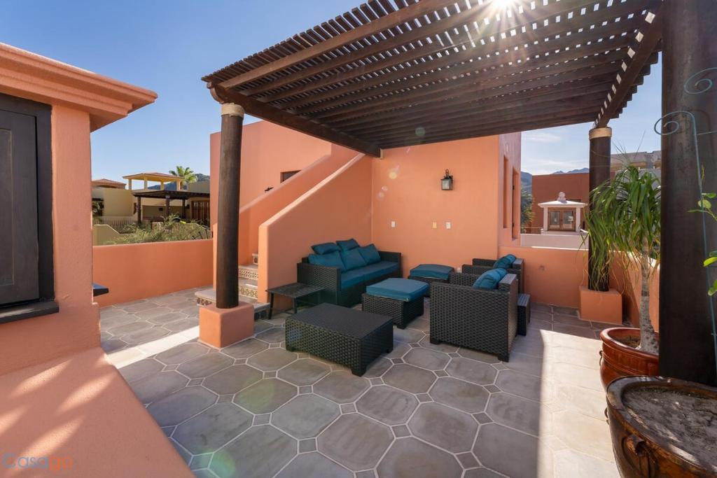 eine Terrasse mit Sofas und Stühlen unter einer Pergola in der Unterkunft Welcome to Casa Sonrisas, charming and peaceful in Nopoló