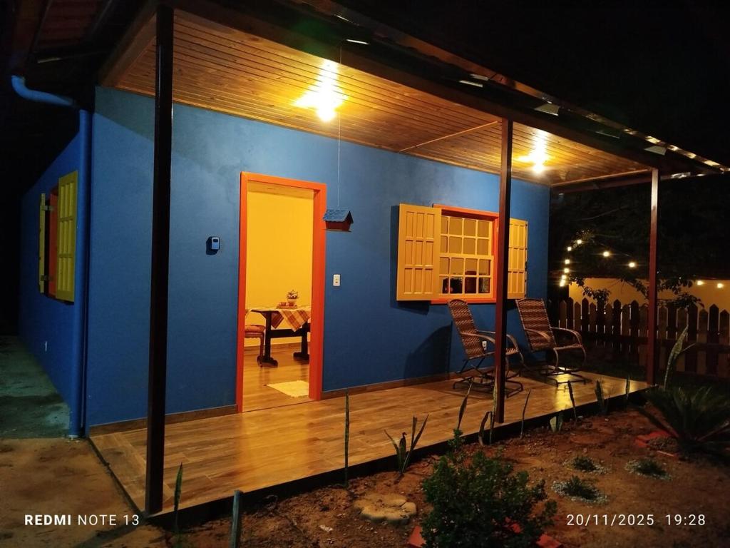 een klein huisje met een terras en een gele deur bij Chalé Emília Costa in Ouro Preto