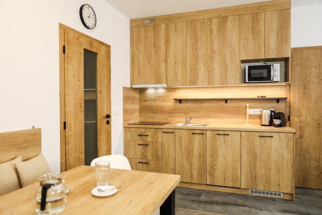 博兹达尔U Božího potoka by Mountain ways的厨房配有木制橱柜、桌子和时钟