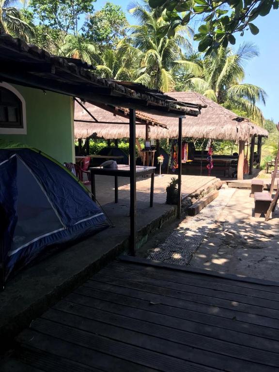 Saco do CeuCamping-Casa Saco do Ceu的棕榈树建筑前的帐篷