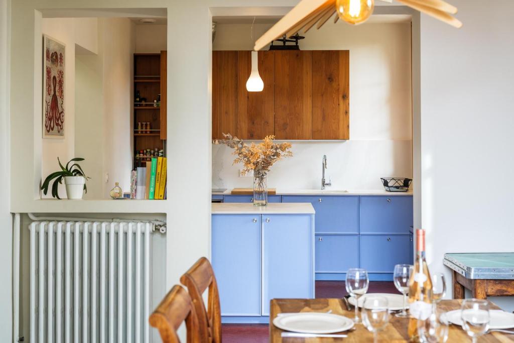 una cucina con mobili blu e un tavolo con sedie di Maison la Nicoise a Vence