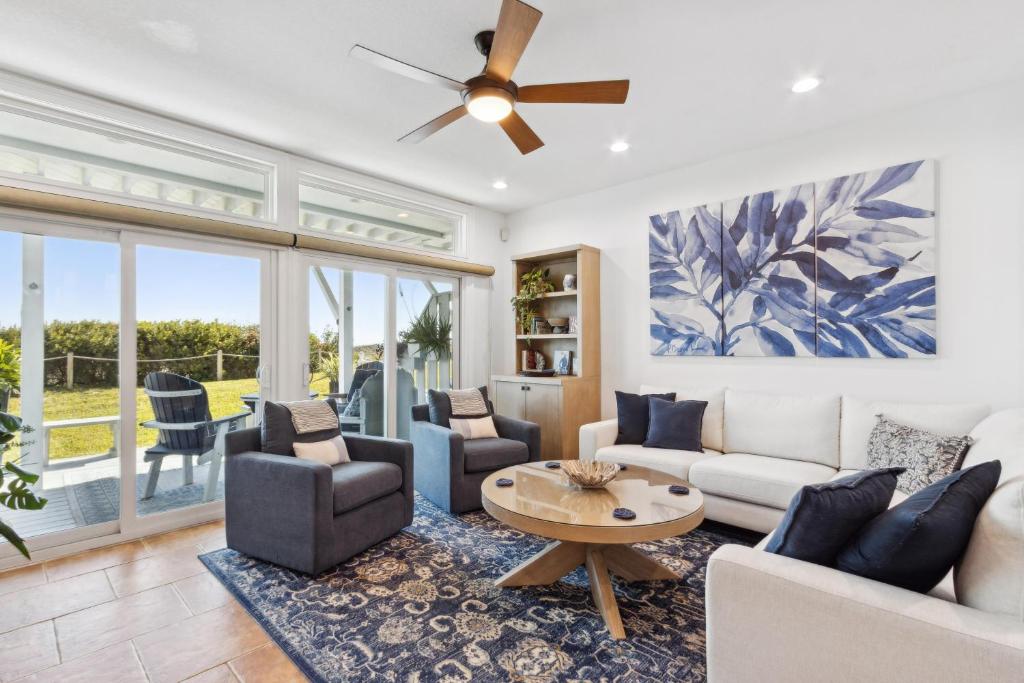 uma sala de estar com um sofá e cadeiras e uma ventoinha de tecto em 95100 Sandpiper em Fernandina Beach