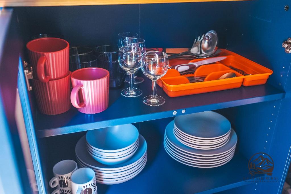 een blauwe plank met borden, glazen en kopjes bij La Llave Rural in Benaocaz