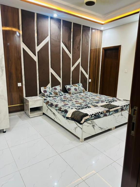 un letto in una stanza con una parete di legno di Peaceful Stay 2nd Home Appartment a Faisalabad