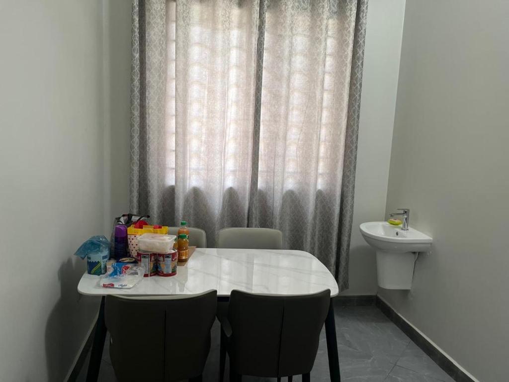 a white table with chairs and a toilet in a room at home in Nungwi