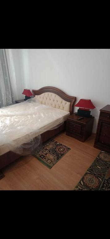 a bedroom with a bed with two lamps and a table at Apartament LUXURY Cluj in Floreşti
