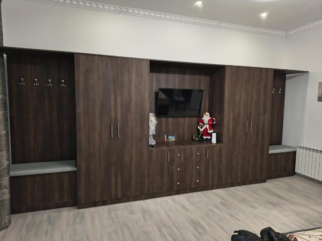 een kamer met houten kluisjes en een tv aan de muur bij Brukenthal House in Sibiu