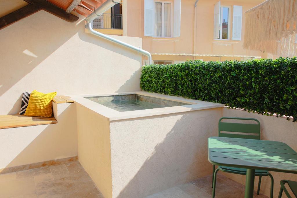 a small terrace with a table and a chair at Suite Cigale Jaune avec terrasse et piscine à Antibes in Antibes