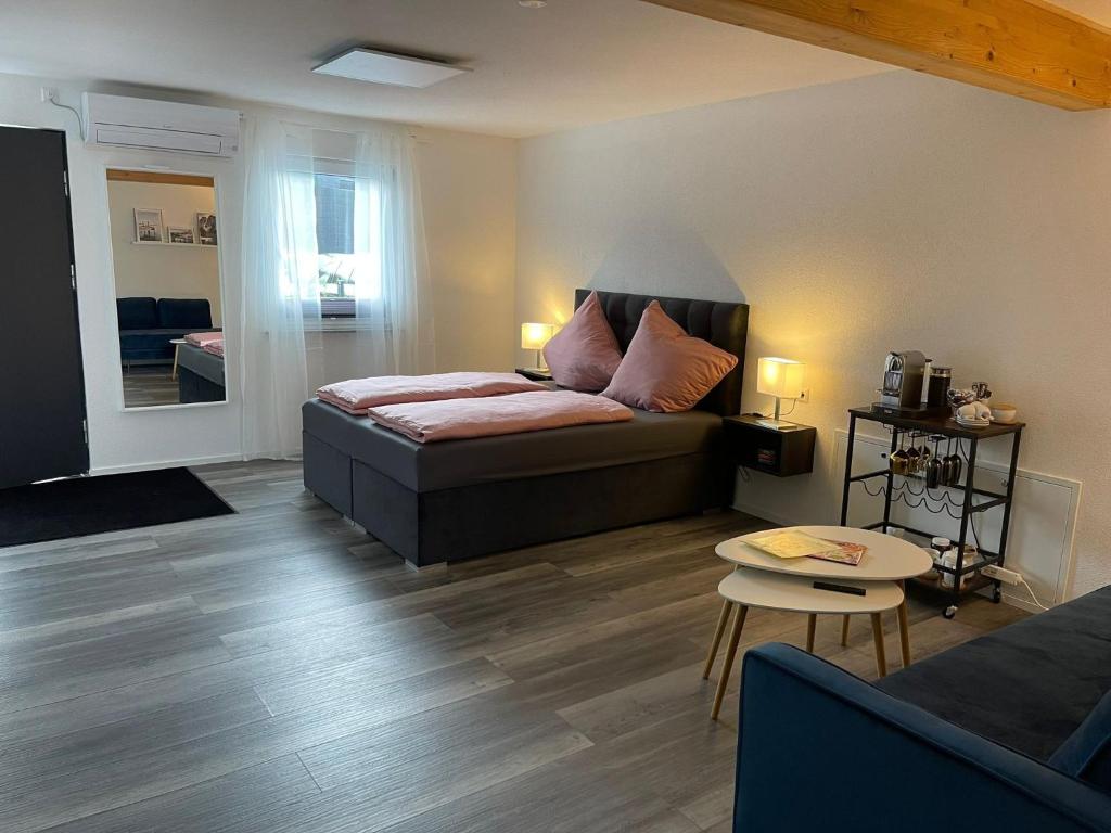 a bedroom with a bed and a living room at Haus Ambiente - 4 Fewos in Bad Säckingen