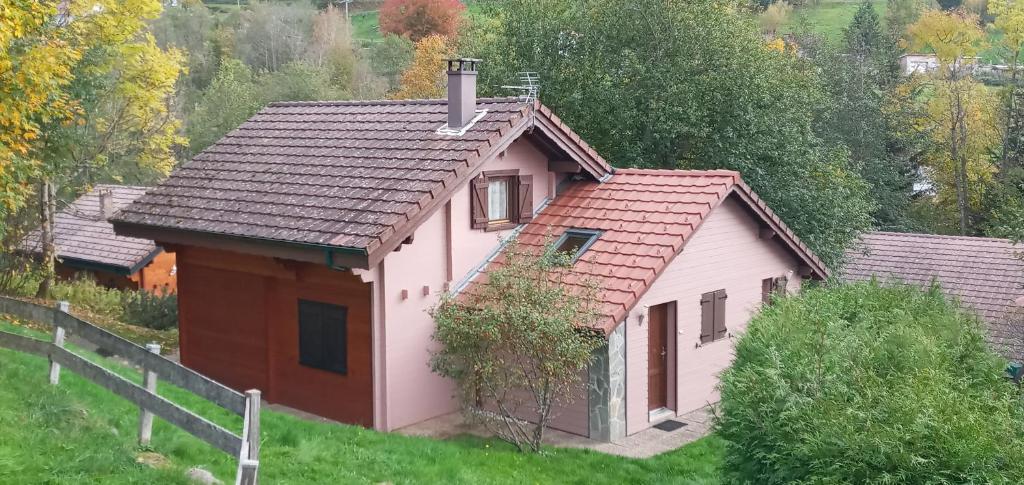 une petite maison blanche avec un toit rouge dans l'établissement Chalet Les Sapins Argentés, à Gérardmer