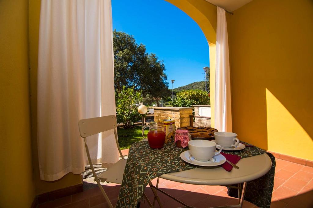 a table with two cups and saucers on it with a window at Quadrilocale Stella in Alberese