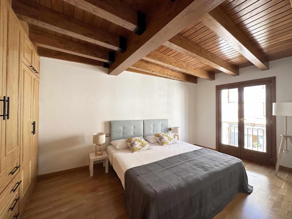 a bedroom with a large bed in a room with wooden ceilings at Casa Baronia - La Cerdanya in Puigcerdà