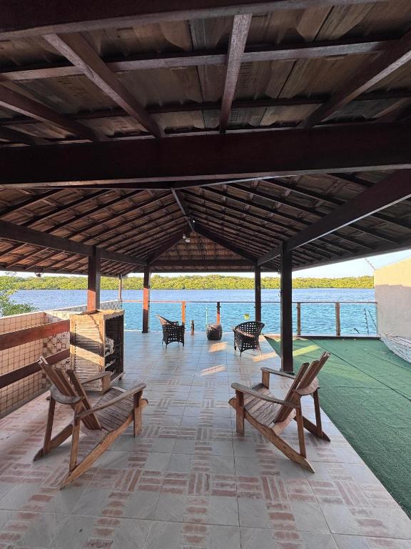 un groupe de bancs assis sur un patio dans l'établissement Casa com Deck e Acesso ao Rio Espaço para Barco 4 Suítes e Área Gourmet, à Aracaju