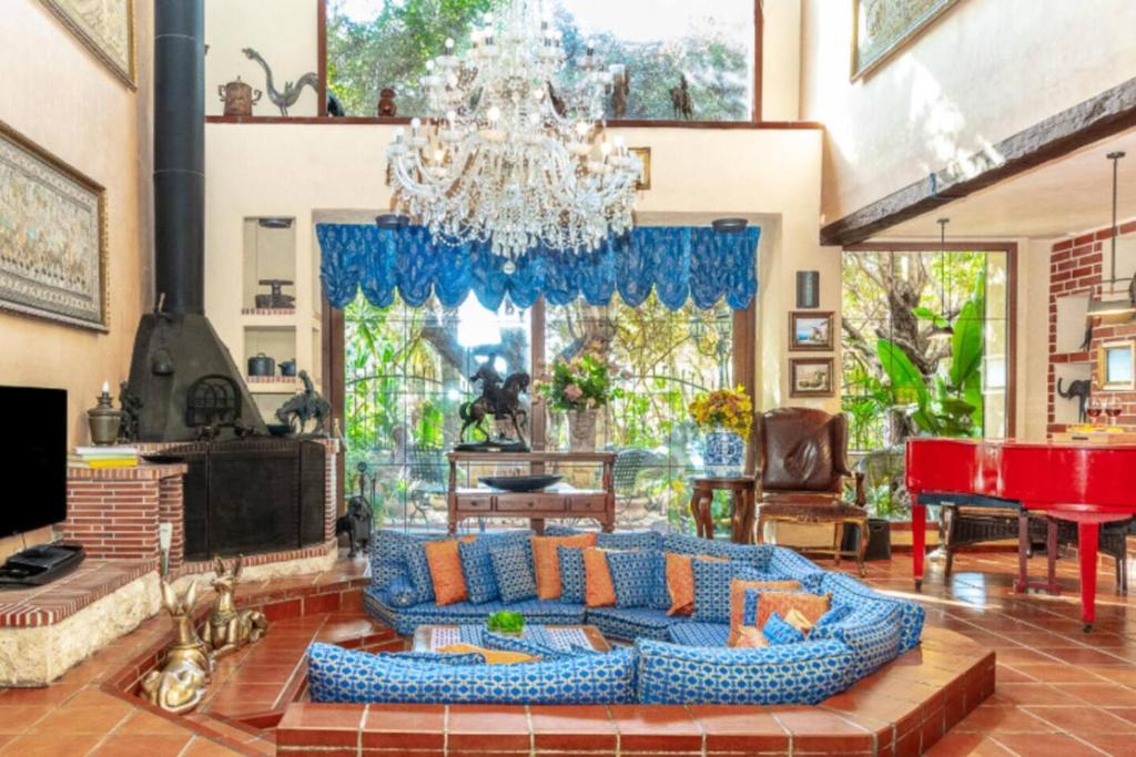 a living room with a blue couch and a chandelier at Luxury Stay Villa de Caesarea in Caesarea