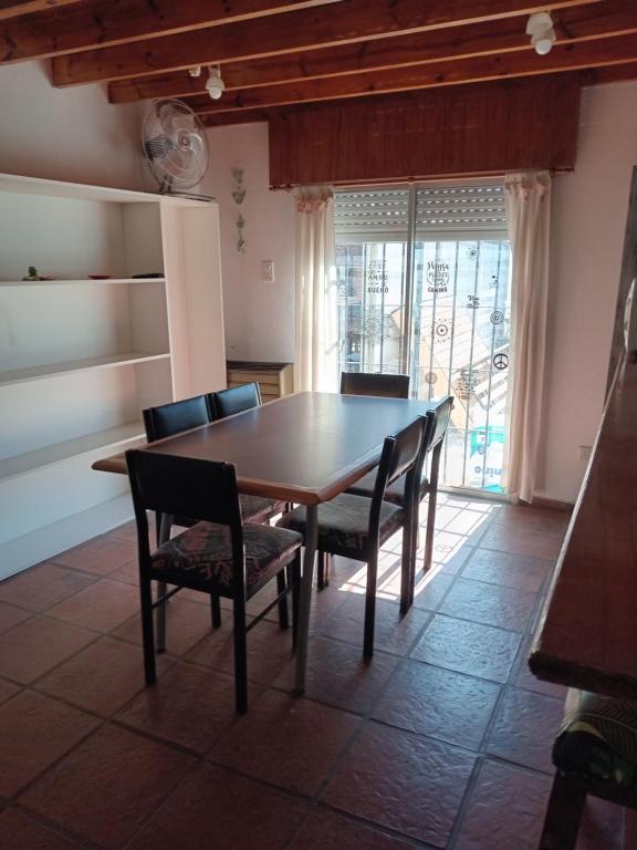 een eetkamer met een houten tafel en stoelen bij Del sur in Mar de Ajó