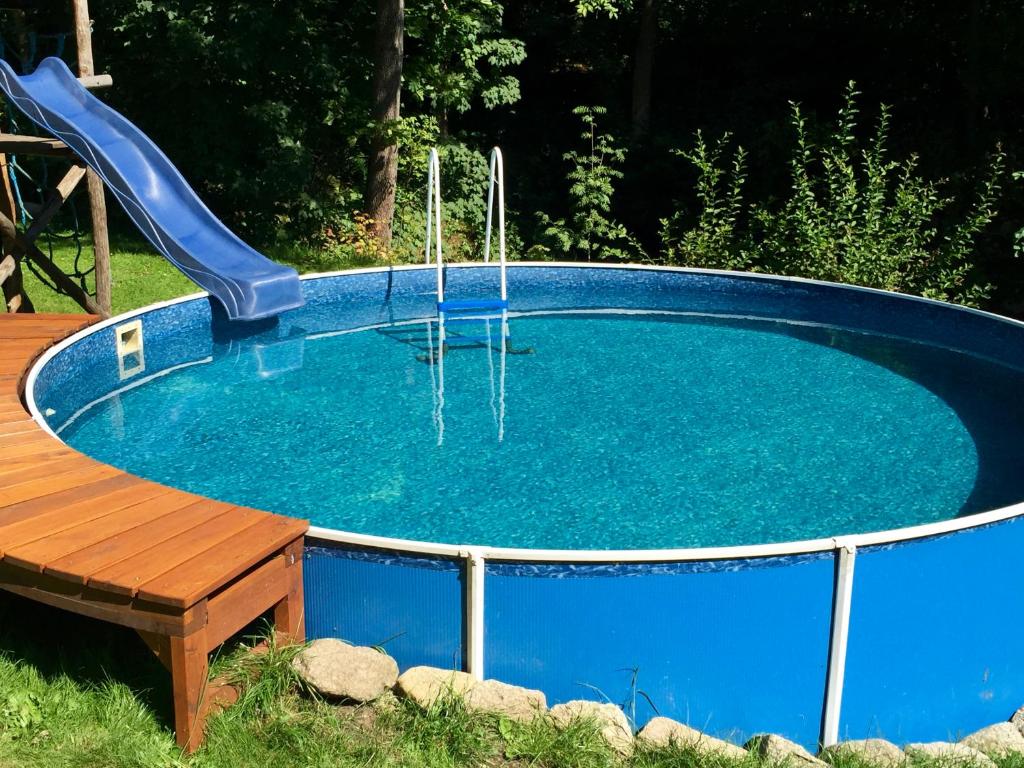 a swimming pool with a slide in it at Chalupa U Potoka in Josefŭv Dŭl
